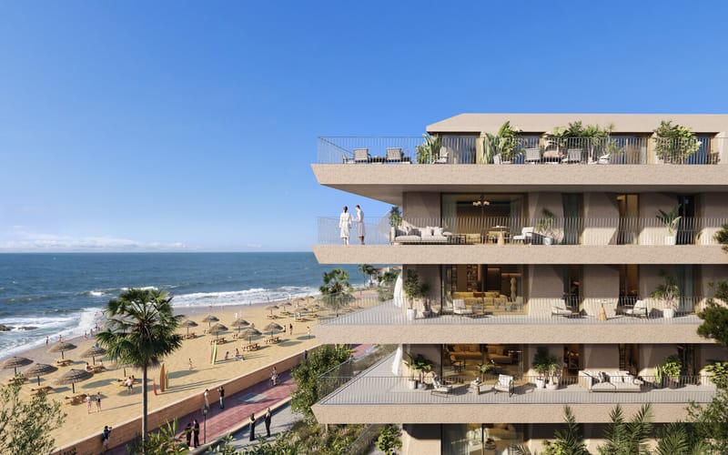 A new-build apartment building on the Costa del Sol seen from the side, its terraces looking out over the beach